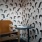 A chair in a room with wallpaper with faces 