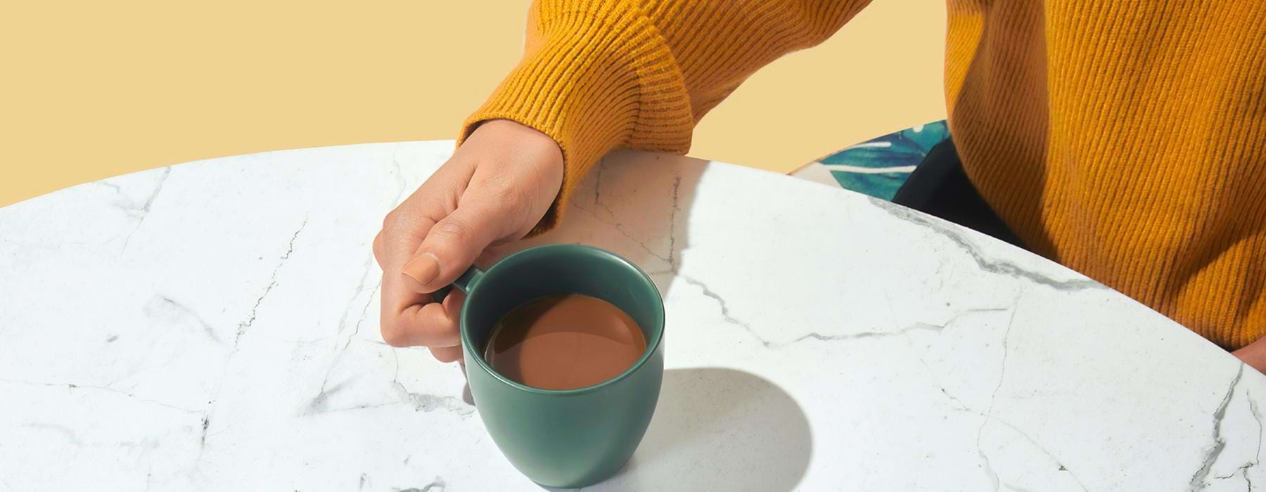 a person holding a cup of coffee